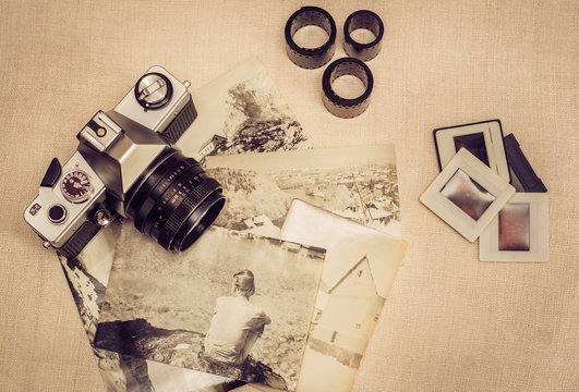 Retro photo camera with old photographs, film rolls and slides. Vintage stylized.