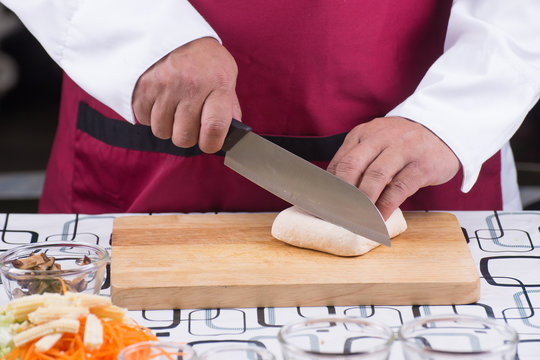Chef slicing tofu for cooking