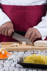 Chef slicing tofu for cooking