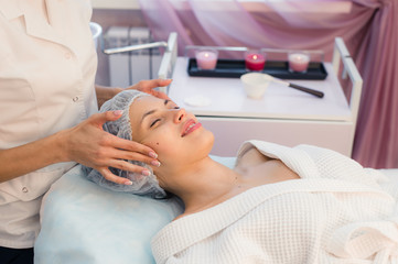 Fototapeta na wymiar Young beautiful woman having spa procedure on her face