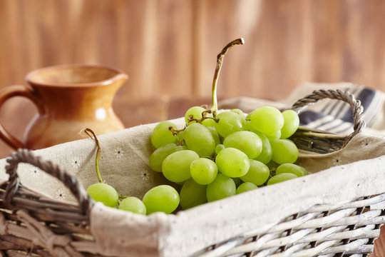 grapes in a basket on an old wooden table