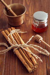 cinnamon sticks on a wooden table with bronze grinder