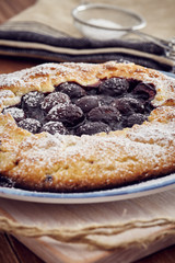 Handmade cherry pie on a blu dish, on a wooden table. Country style.