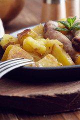 roasted sausages and potatoes on a wooden table