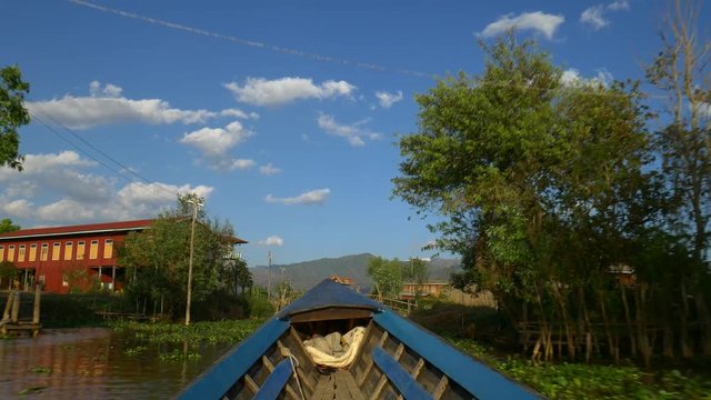 Boat going through traditional floating village, Inle Lake, Myanmar