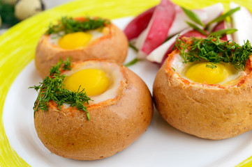 Baked small flavorful bun with bacon, cheese, quail egg and greens. Tasty breakfast. Close up