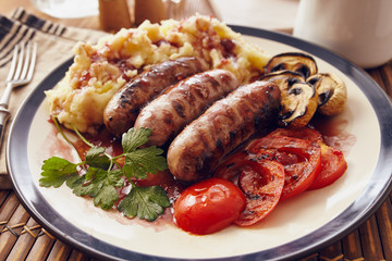 Sausage and mush dish with grilled mushrooms and tomatoes