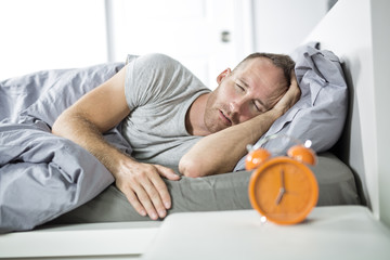 Fototapeta premium Time to wake up. Tired man in the bed