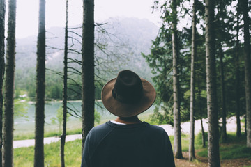 man seen from behind with brow hat and trees and lake on the background - 121560190