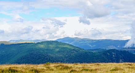 Transalpina road with hills covered with green grass, Parang Mountains