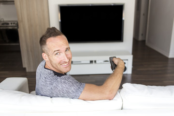 man on sofa linstening TV