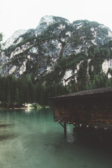 Braies lake with wood building and mountains with trees - 121561755