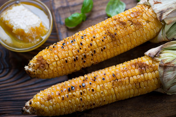 Grilled sweet corncobs with honey and paprika, close-up