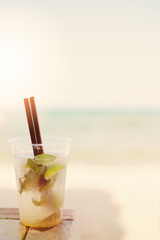 Mojito cocktail on the beach, blurred beach background. Sun, sun haze, glare