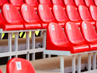 Red plastic armchairs on stadium