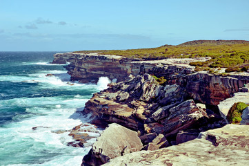 Weathered, rugged sandstone cliffs of Cape Solander, New South Wales coastline, Australia. Battered by wind and waves, rock collapse common.