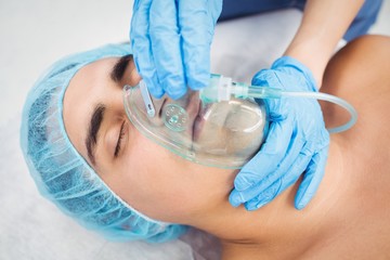 Nurse putting an oxygen mask on patient