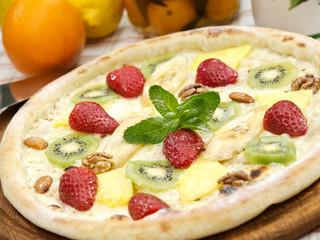 sweet pizza with strawberry, kiwi, banana and nuts 