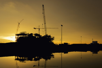 Oil refinery construction in silhouette