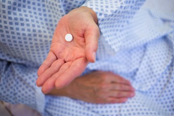Close-up of senior patients hands holding medicine