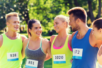 happy friends or couple with racing badge numbers