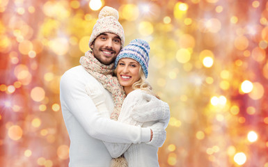 smiling couple in winter clothes hugging