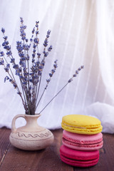 French macaroons and lavender on wooden table. Vintage toned food still life.