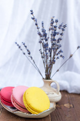 French macaroons and lavender on wooden table. Vintage toned food still life.