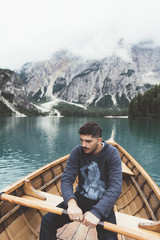 Man rowing a wood boat at Braies lake - 121569993
