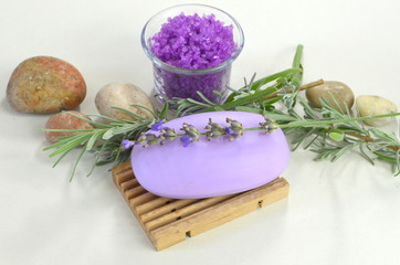 Fototapeta na wymiar Натуральное мыло с лавандой на подставке, веточки лаванды, морская соль с лавандой и морские камни