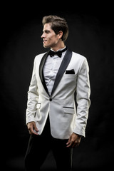 elegant man in a white suit tuxedo with bow tie around his neck
