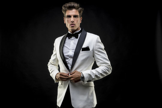Handsome, elegant man in a white suit tuxedo with bow tie around