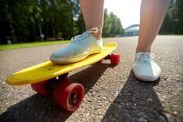 close up of female feet riding short skateboard