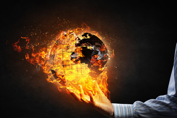 World globe in fire . Mixed media