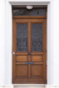 An elegantly carved, beautiful brown wooden door of a mansion in the city of Basel, Switzerland.