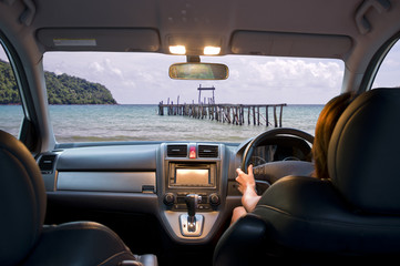 Woman travel by four wheel drive car on beach.