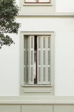 Window of an old mansion with green wooden shutters in the city of Basel, Switzerland.
