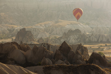 Hot air balloon flying over rock landscape at Cappadocia Turkey