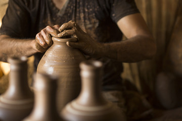 Fototapeta premium Hands of young potter, was produced on range of pot.