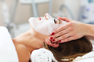 Obraz na płótnie Canvas Woman with facial mask in beauty salon