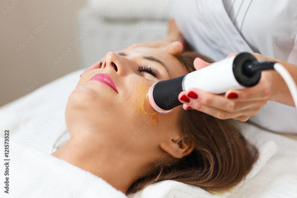 Wall mural woman having facial peeling in beauty salon