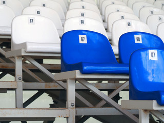 Blue and white plastic armchairs on stadium