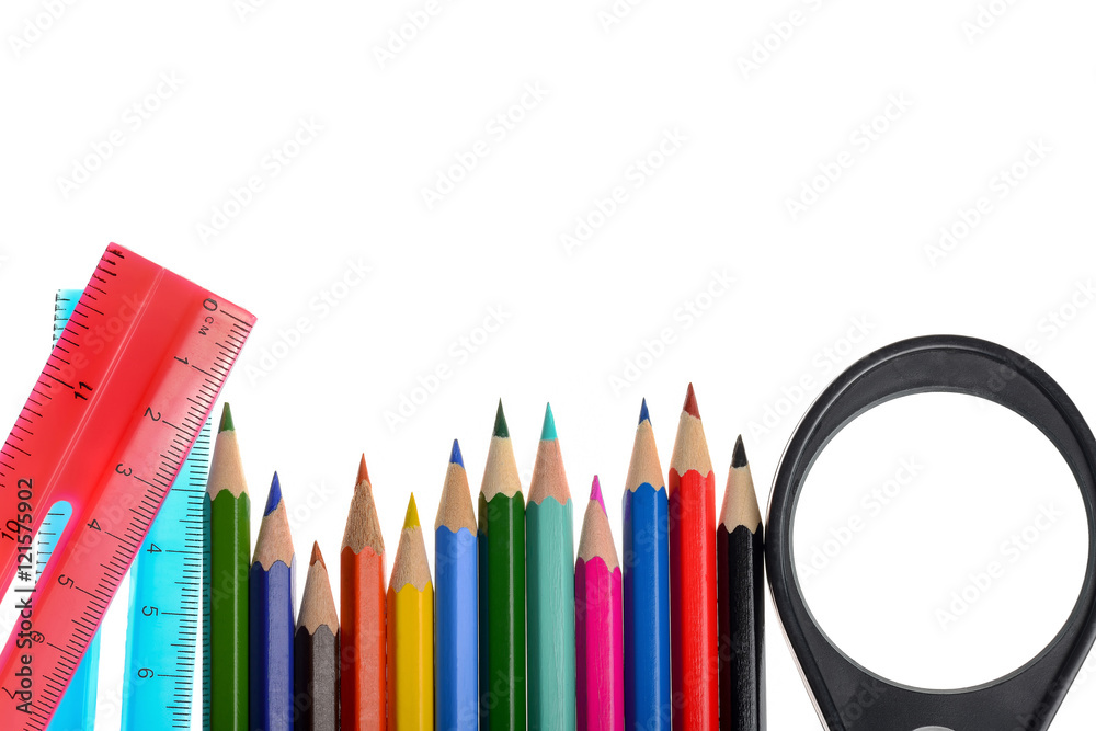 Wall mural crayons, magnifying glass and two ruler arranged in white surface