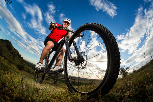 cyclist riding mountain bike on rocky trail at sunrise