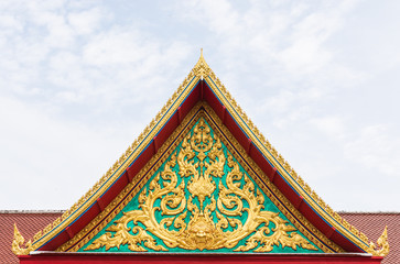 golden ancient texture on emerald wall infront of temple roof.