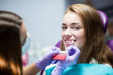 Dentist curing a woman patient in the dental office in a pleasant environment. There are specialized equipment to treat all types of dental diseases in the office.