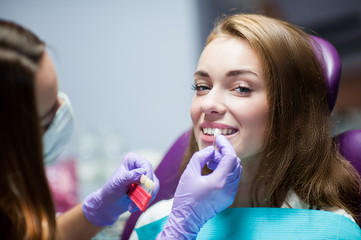 Dentist curing a woman patient in the dental office in a pleasant environment. There are...