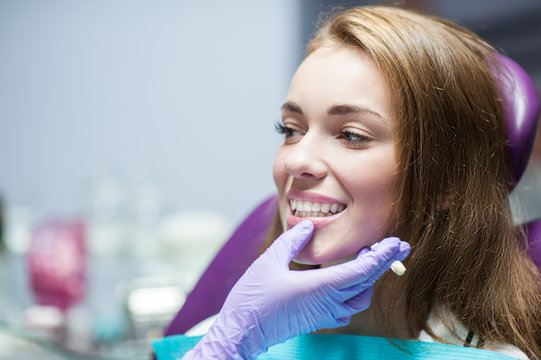 Dentist curing a woman patient in the dental office in a pleasant environment. There are specialized equipment to treat all types of dental diseases in the office.