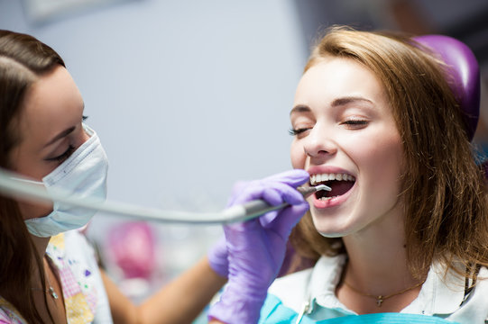 Dentist curing a child patient in the dental office in a pleasant environment. There are specialized equipment to treat all types of dental diseases in the office.