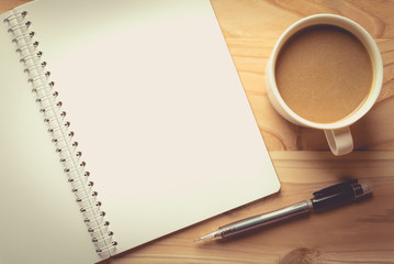 notebook checked with a pencil and a cup of coffee , vintage